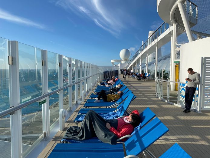Er heerst geen paniek op het cruiseschip: passagiers proberen al zonnend de tijd te doden.