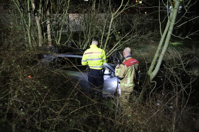De politie onderzoekt de auto die in de bosjes terechtkwam.