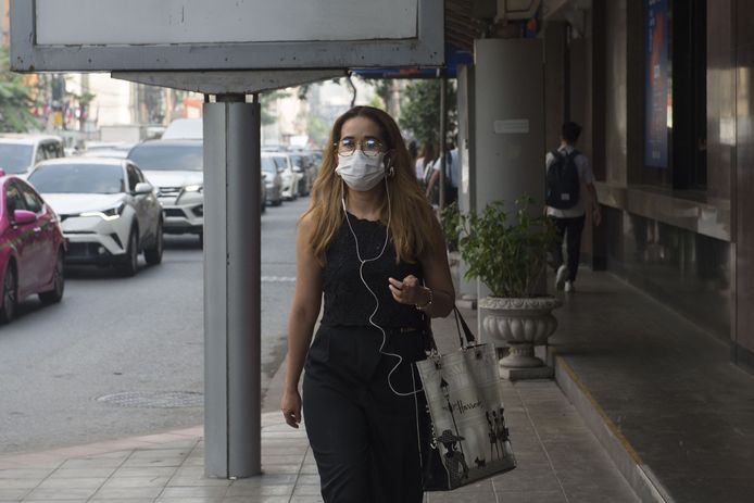 Om zich te beschermen tegen het fijn stof, dragen de inwoners een mondmasker.