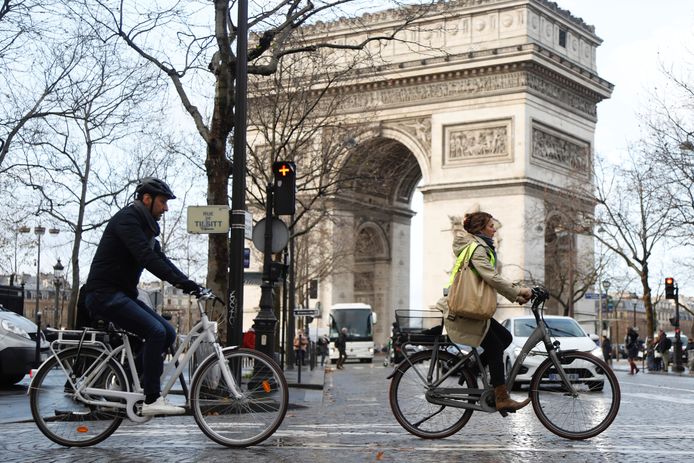 Mensen passeren tijdens het spitsuur per fiets de Arc de Triomphe in Parijs, waar alle transportvakbonden al meer dan een week in staking zijn.