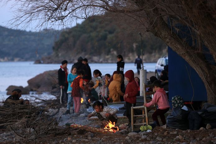 Vluchtelingen warmen zich op aan een kampvuurtje op het Griekse eiland Lesbos.