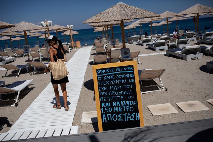 Een strand op het eiland Kos. Een bord maant aan om de social distancing te respecteren.
