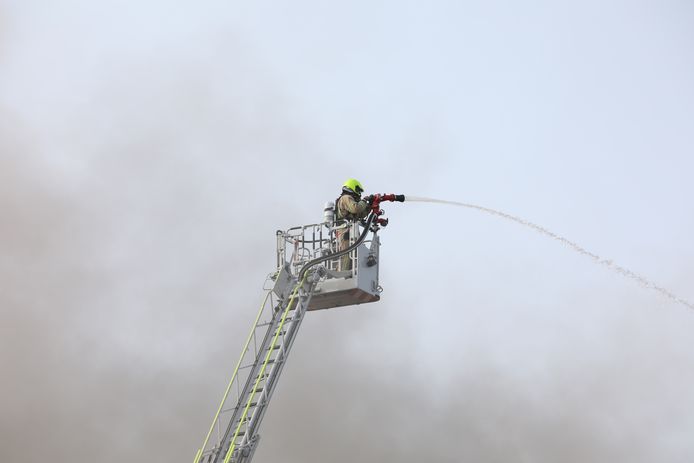 Een brandweerman probeert het vuur te bedwingen.