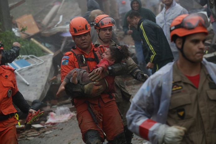 Reddingswerkers dragen een vier jaar oud meisje dat uit een ingestort huis werd gehaald in Petrópolis. (24/03/24)