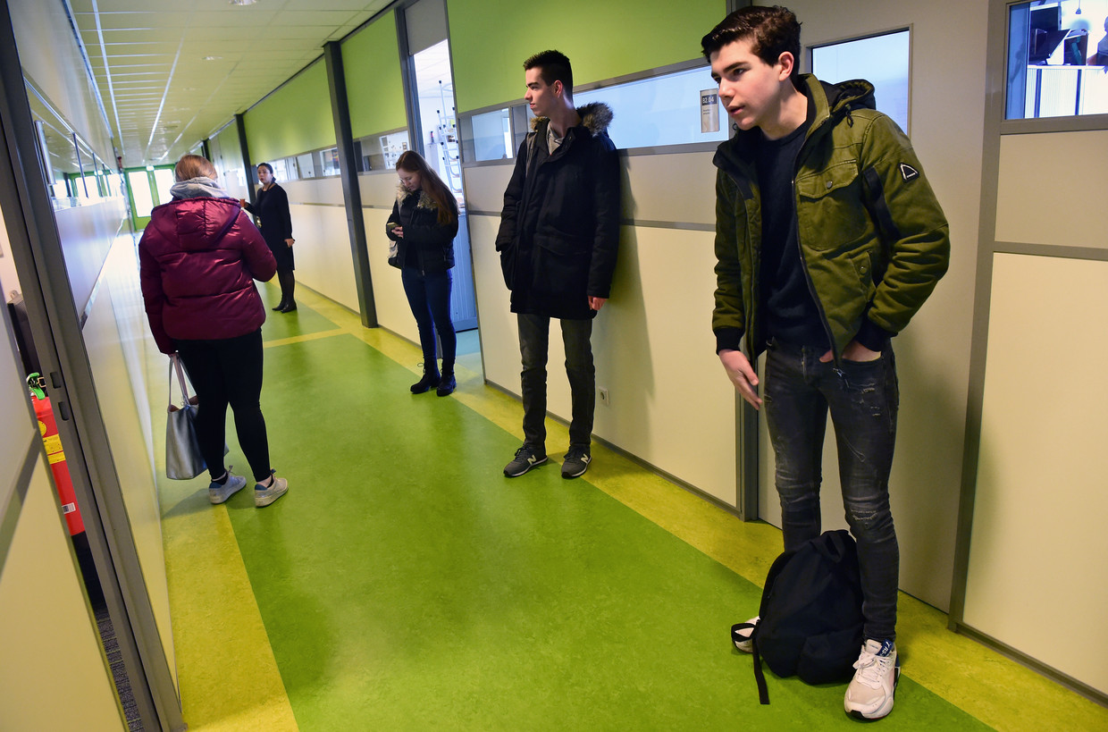 Julien Tromp (rechts) wacht op afstand van andere leerlingen op zijn examen in het Dr. Mollercollege in Waalwijk.  Beeld Marcel van den Bergh / de Volkskrant