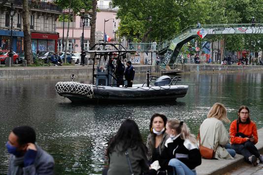 Een politieboot in Parijs. Parijzenaars lijken weer gezellig samen te komen, ondanks de oproep van de overheid om afstand van elkaar te bewaren.  