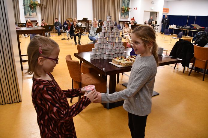 Het vijftigste lid van Harmonie Volharding in Dinteloord is Lotte Walbeek (links). De 8-jarige krijgt een cadeautje van leeftijdsgenoot en medelid Annamarit Molenaars (rechts).