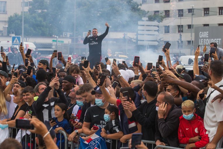 PSG-fans proberen bij het vliegveld Le Bourget een glimp op te vangen van hun idool Messi. Beeld EPA