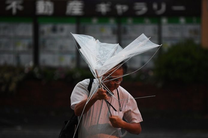 Een man vecht met zijn paraplu in Tokio.