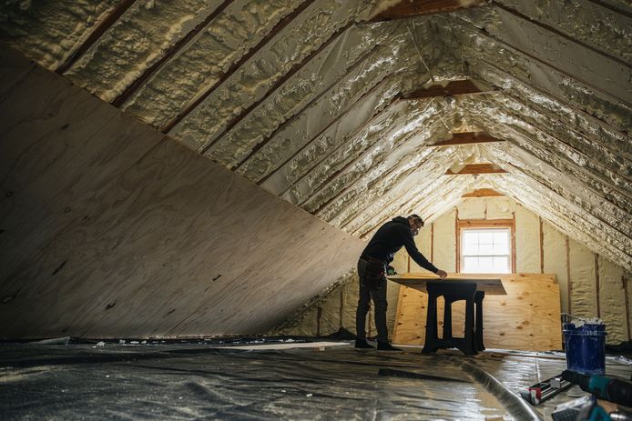 Een man is druk bezig met het isoleren van een woning.