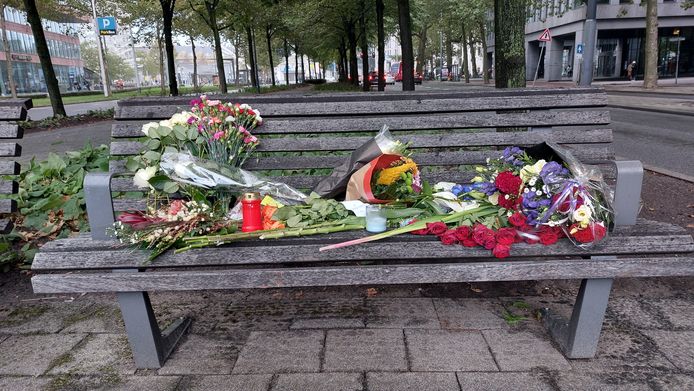 Bloemen op het bankje waar de 24-jarige Rotterdammer zaterdagochtend ernstig gewond werd aangetroffen.