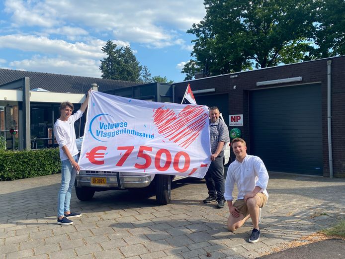 De mannen van de Veluwse Vlaggenindustrie brengen hun vlag en het bedrag bij het Rode Kruis in Apeldoorn.