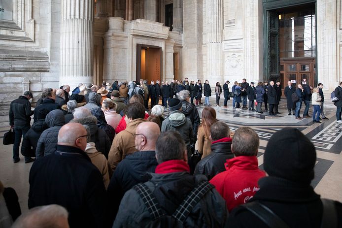Een lange rij wachtenden schuift aan om het vonnis bij te wonen in de Brusselse rechtbank.
