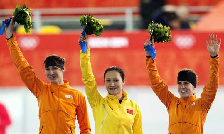 Bloemen in de handen van de medaillewinnaars bij de 1000 meter schaatsen gisteren: Margot Boer, Hong Zhang en Ireen Wüst (van links naar rechts). Beeld anp