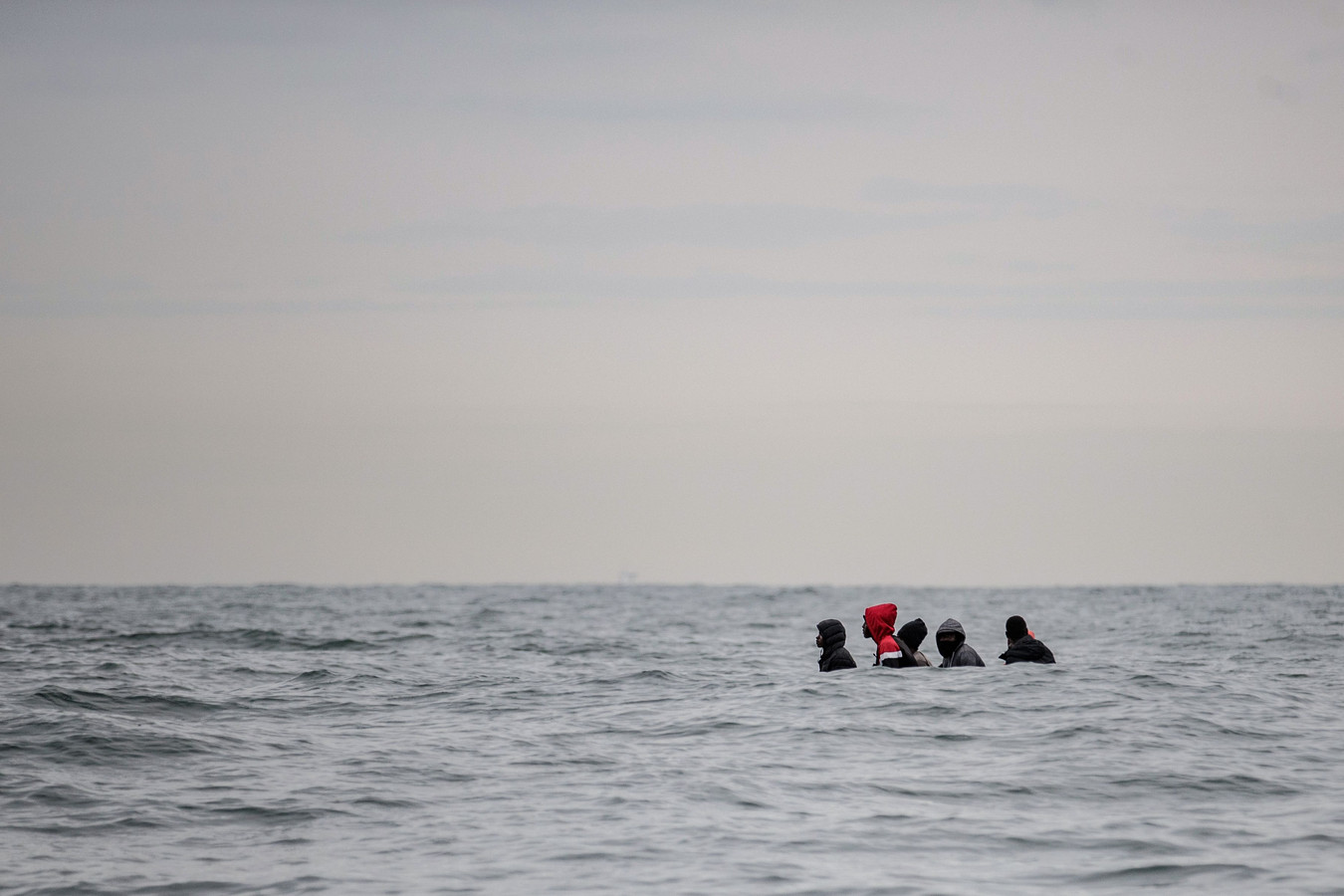Des migrants sont assis à bord d'un bateau naviguant dans des eaux agitées entre Sangatte et le Cap Blanc-Nez, dans la Manche, au large des côtes du nord de la France, alors qu'ils tentent de franchir les frontières maritimes entre la France et le Royaume-Uni.