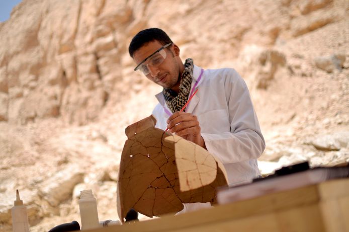 Een archeoloog onderzoekt een van de waardevolle stukken die aan de oppervlakte kwamen in Luxor.
