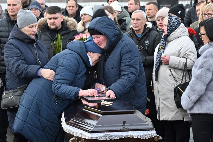 Mensen rouwen bij een kist van familielid dat eind vorige week stierf na een droneaanval op Charkiv. (12/2/2024)