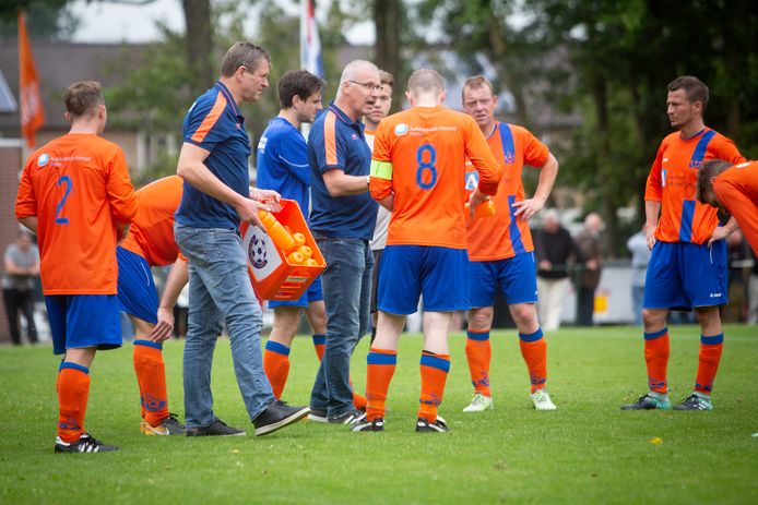 Trainer Adrie van Roosmalen spreekt zijn spelers toe.