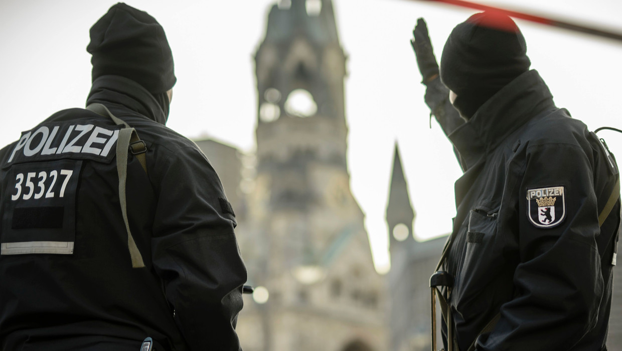 Twee agenten houden de wacht bij de Gedächtniskirche in Berlijn, waar maandagavond een vrachtwagen op een kerstmarkt inreed. Beeld AFP