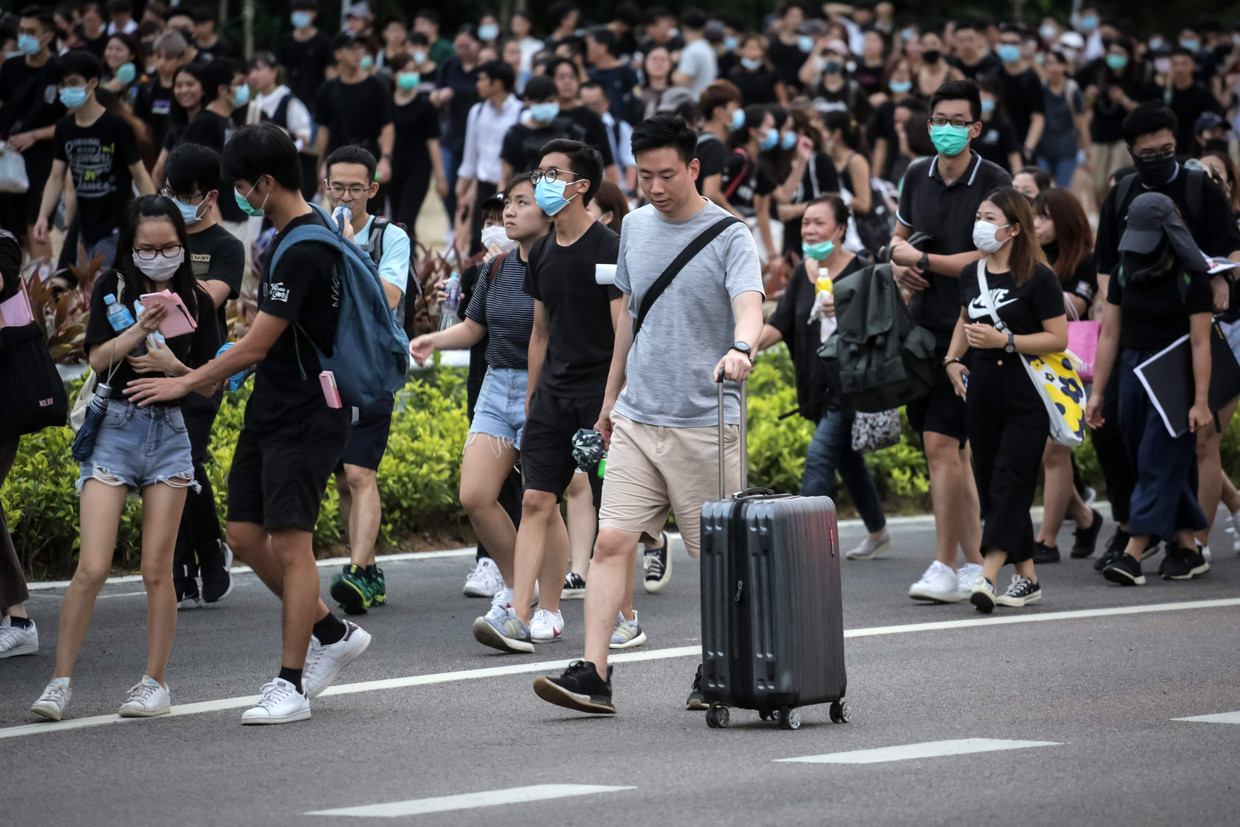 Een gestrande passagier verlaat het vliegveld van Hongkong, net als veel demonstranten.  Beeld AFP
