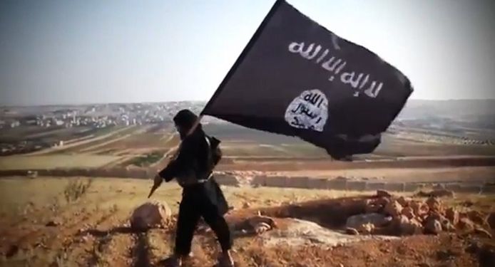 Een jihadist met de vlag van IS, archiefbeeld.