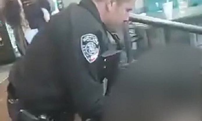Een politieman helpt een gewond slachtoffer in de bowlinghal.