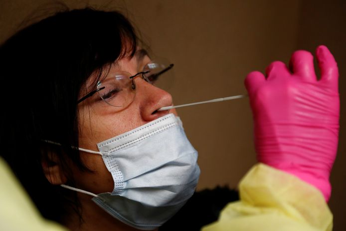 Een vrouw wordt in Brussel getest op de aanwezigheid van het coronavirus.