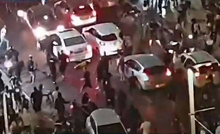 Een still van de live-utizending van nieuwszender Kan News waarop te zien is hoe een vermoedelijk Arabische man uit een auto wordt getrokken en mishandeld.  Beeld AFP