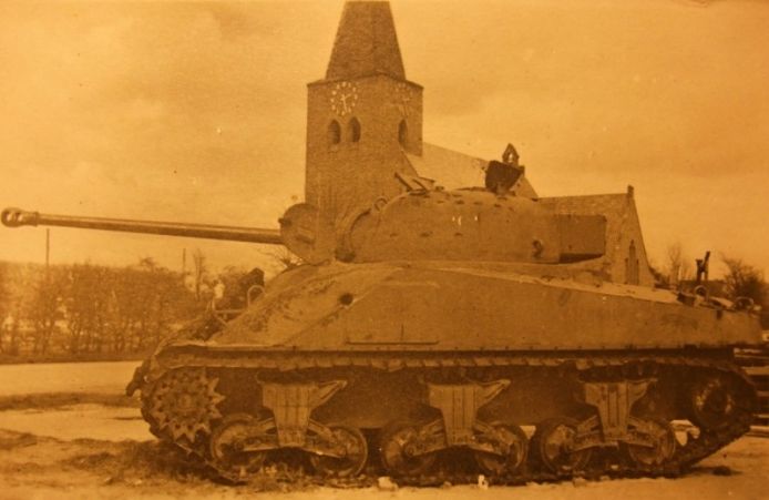 Een gehavende geallieerde tank voor de kerk in Megchelen. De tank was lang een oorlogsmonument in het dorp. collectie Peter Bresser