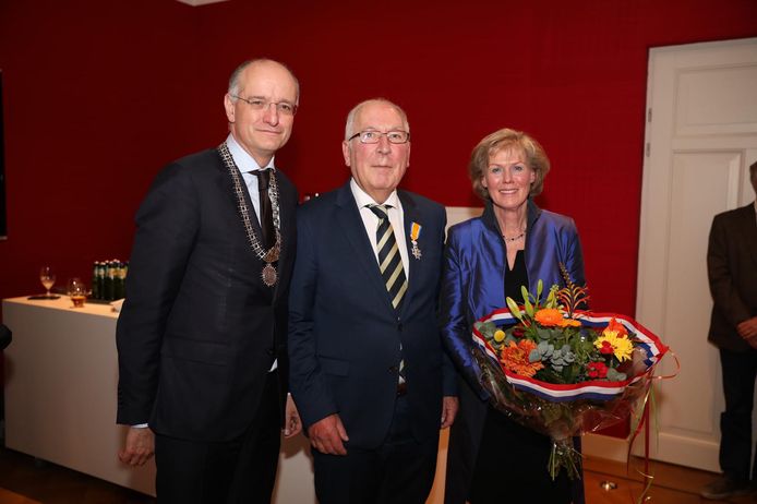 Rasbestuurder Henk van der Sijs (midden) uit Enschede is geridderd bij het eeuwfeest Bond van Confectiefabrikanten.