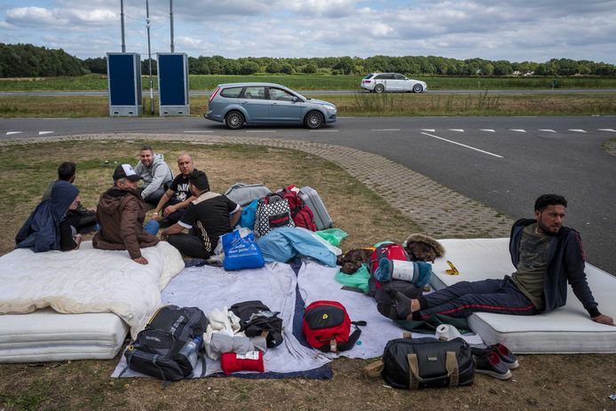 Asielzoekers zondag buiten de poort bij het aanmeldcentrum in Ter Apel.