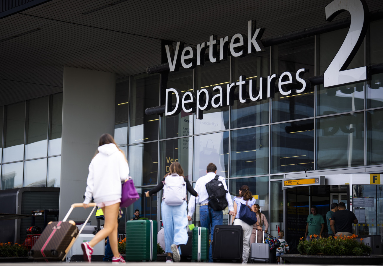 Reizigers op Schiphol op weg naar hun bestemming.