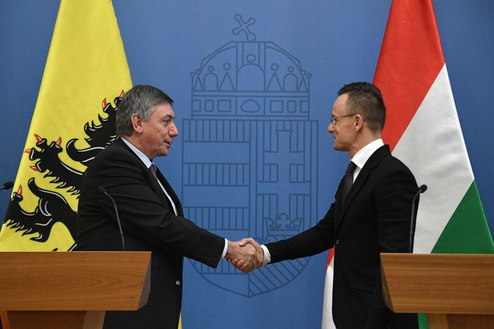 De Vlaamse minister-president Jan Jambon en de Hongaarse minister van Buitenlandse Zaken Peter Szijjarto schudden elkaar de hand.