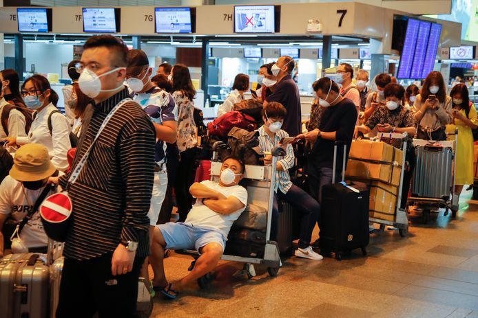Wachtende toeristen dragen mondmaskers op de Don Mueang-luchthaven in Bangkok. Ook in Thailand zit de schrik er goed in door de uitbraak van het coronavirus.