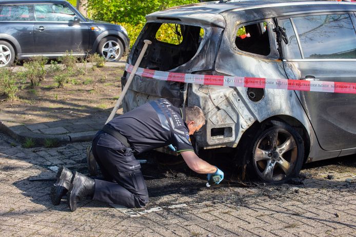 De politie doet onderzoek bij de uitgebrande auto in de Van Polanenstraat in Ambacht.