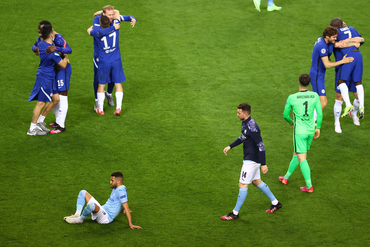 Riyad Mahrez zit verslagen op de grond, terwijl de spelers van Chelsea de triomf in de Champions League-finale vieren.  Beeld AFP