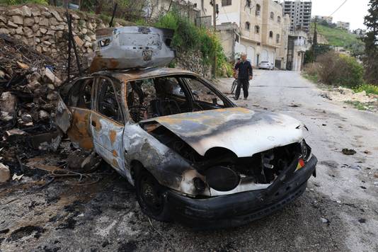 Een Palestijnse man onderzoekt een uitgebrande auto na een nachtelijke inval van Israëlische soldaten in een vluchtelingenkamp in Jenin, op de Westelijke Jordaanoever.