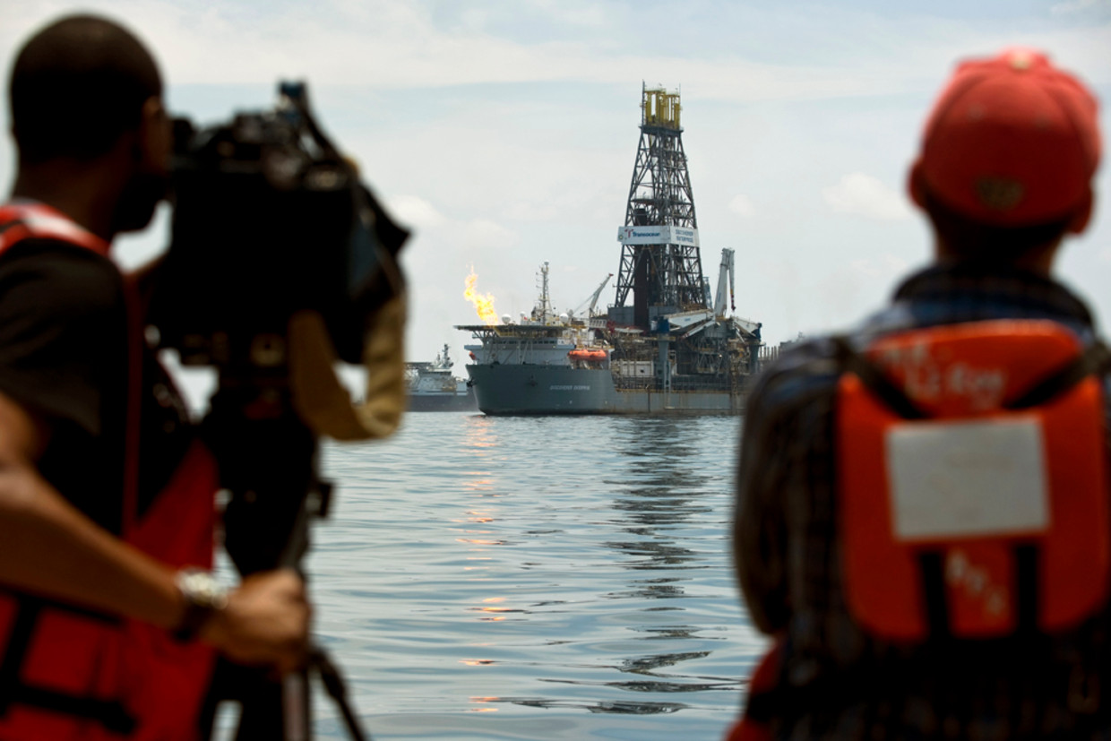Een televisieploeg filmt de Discoverer Enterprise. Deze fakkelt gas af en vangt olie op uit het lek van het gezonken olieplatform Deepwater Horizon voor de kust van Louisiana, Verenigde Staten (ANP) Beeld 