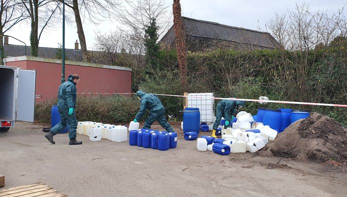 Een gespecialiseerd bedrijf haalt de vaten weg. Medewerkers dragen speciale pakken.