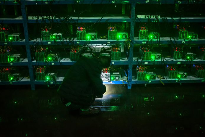 Een werknemer van een Chinese bitcoinbeurs contoleert computers in de Chinese provincie Sichuan.