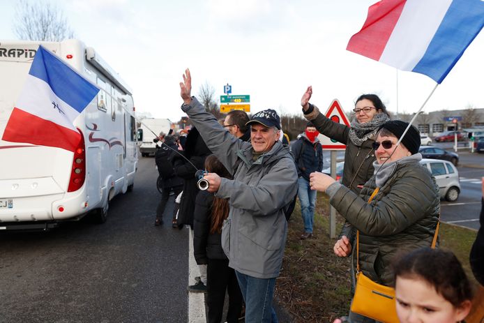 Mensen zwaaien naar het 'Vrijheidskonvooi' dat onderweg is naar Parijs.