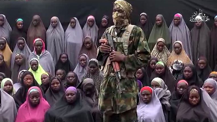 Een gemaskerde Boko Haram-strijder houdt een toespraak voor de ontvoerde meisjes.  Beeld AFP