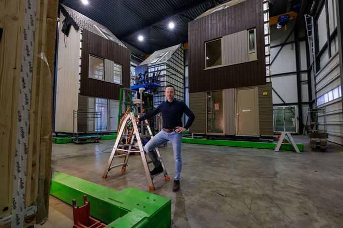 Directeur Tony Mol voor zijn houten huizen in de fabriek.