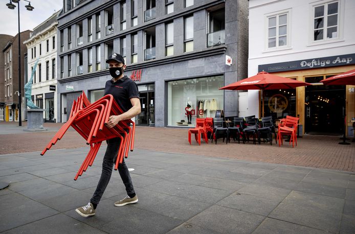 Een terras wordt opgebouwd bij een horecazaak in Helmond. Een groep van 65 regionale afdelingen van Koninklijke Horeca Nederland roept horecaondernemers op om 2 maart de terrassen te openen.