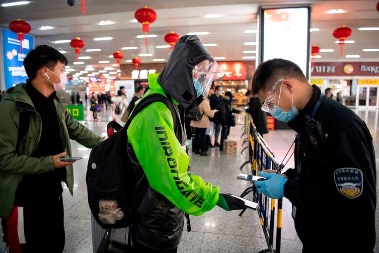 Een passagier op het station van Wenzhou laat zijn groene QR-code zien, die laat zien dat zijn gezondheidsstatus goed is. Beeld AFP