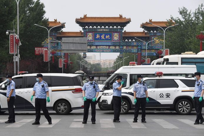 Chinese politieagenten bewaken de ingang van de Xinfadi-markt in Peking
