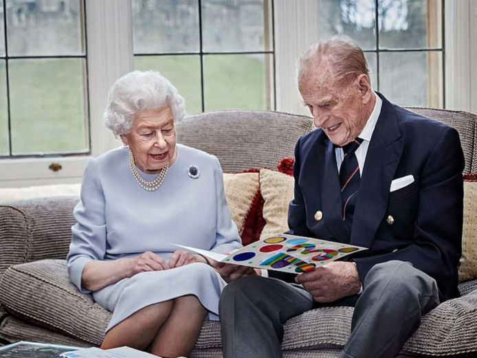 De queen en prins Philip bekijken een kaartje van hun kleinkinderen.