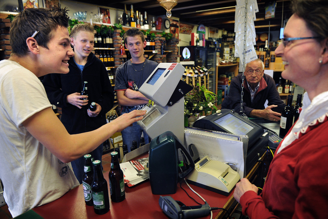Een jongen koopt bier bij de slijter. Beeld Marcel van den Bergh / de Volkskrant