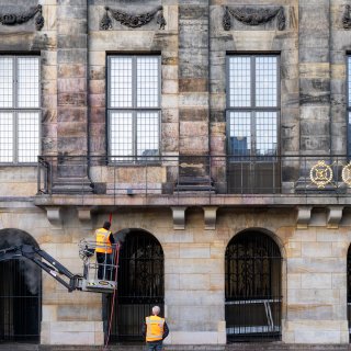 Rode verf op Paleis op de Dam maand na bekladding nog steeds te zien: ‘Zandsteen schoonmaken is vakwerk’