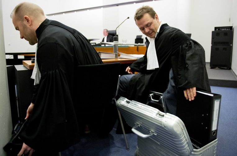 De advocaat van Sabir K., Andre Seebregts (R), neemt in december 2013 het dossier ter hand van de Nederlandse terreurverdachte in de rechtbank van Den Haag. Beeld anp